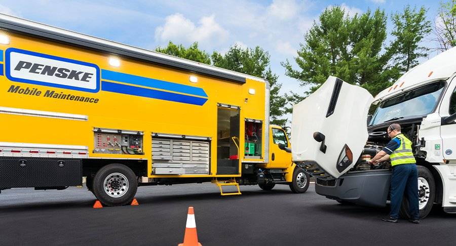 A certified Penske technician works on a truck.