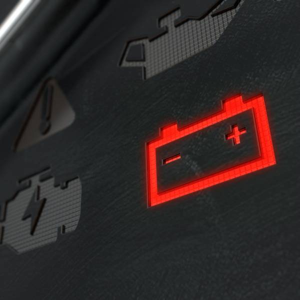 A closeup shot of a lit up red battery icon on the dashboard of a vehicle.