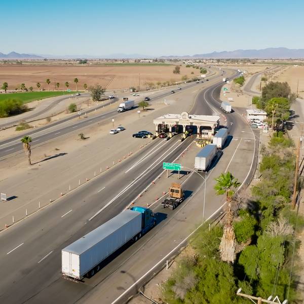 A line of semi-trucks waits for inspections at an inspection station in California.