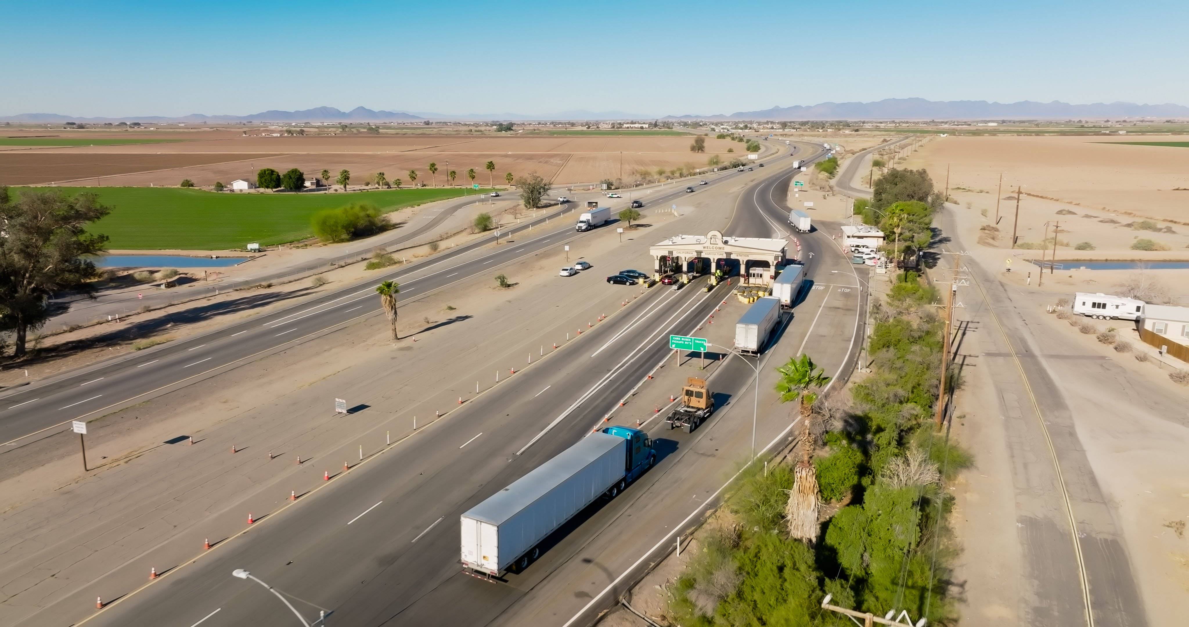 A line of semi-trucks waits for inspections at an inspection station in California.
