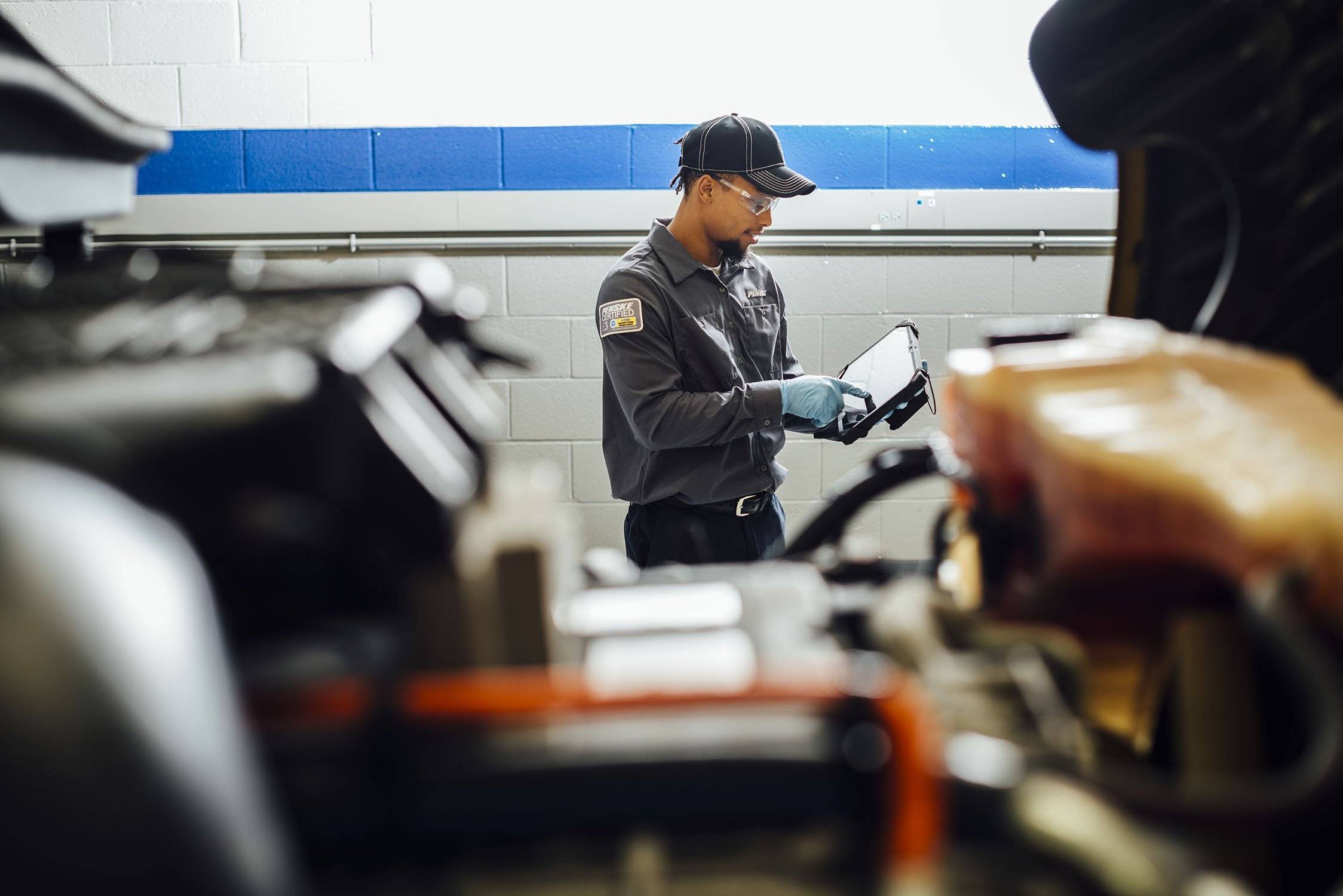 A maintenance technician documents something on an ipad.
