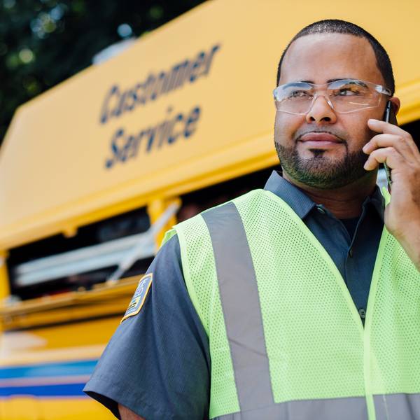 A Penske Maintenance tech on the phone by his truck.