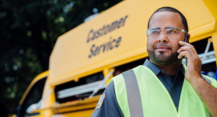 A Penske Maintenance tech on the phone by his truck.