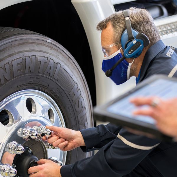 A Penske mechanic works on a truck tire.