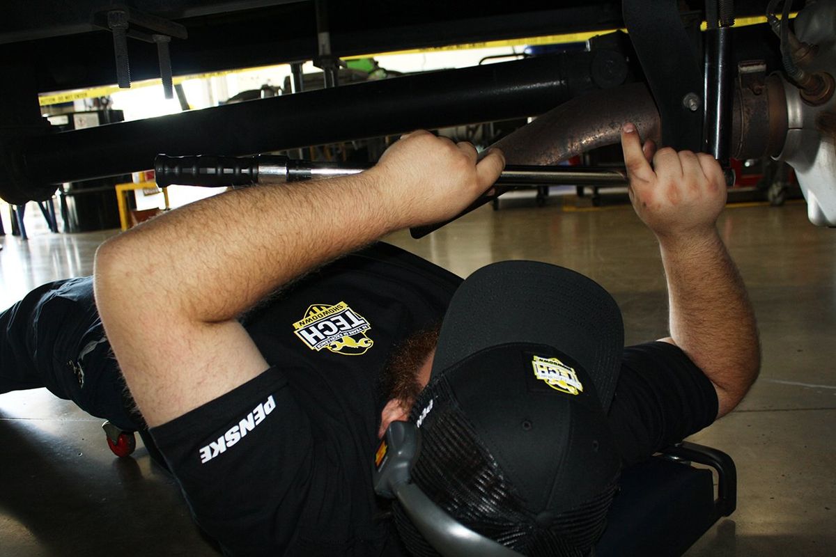 A Penske technician performs a hands-on inspection as part of the 2025 Tech Showdown competition.