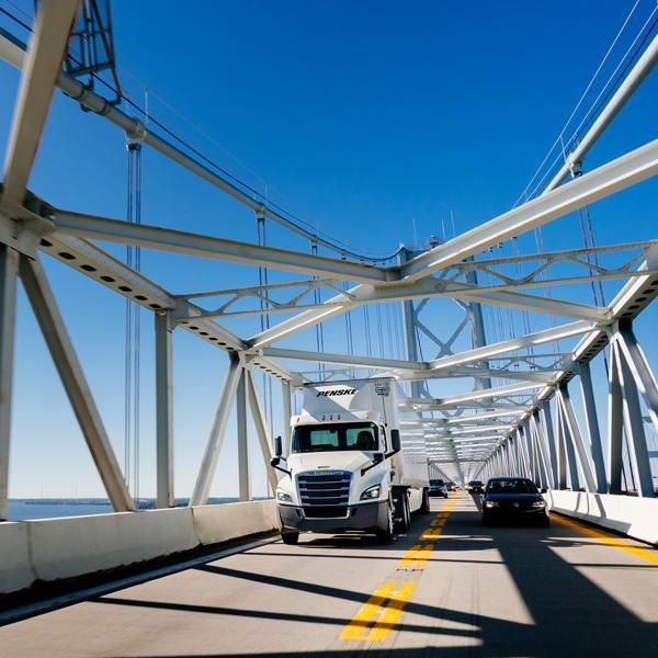 A Penske truck and car practicing safe summer driving.