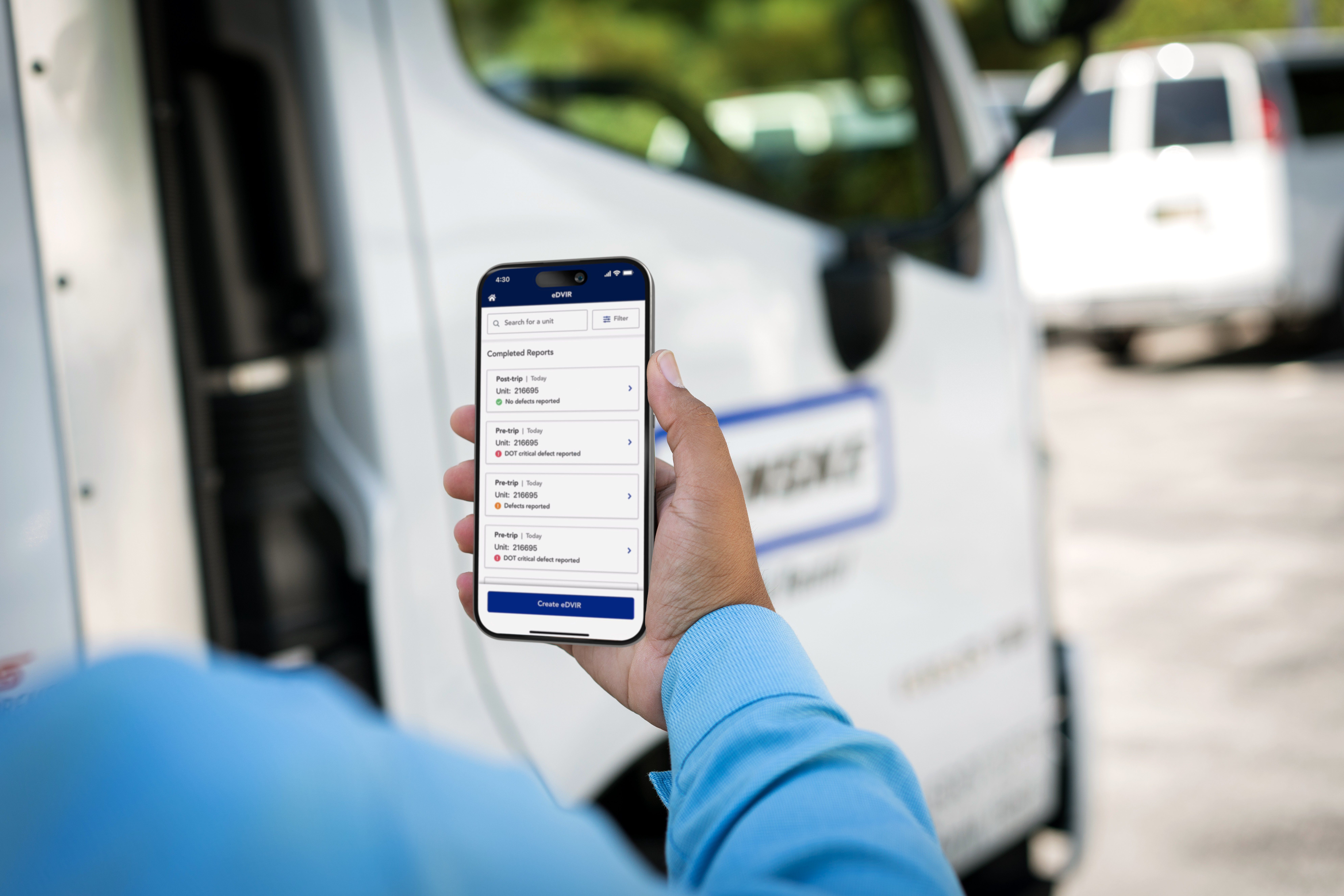 A person holds a smartphone displaying the Penske Driver mobile app's eDVIR feature.