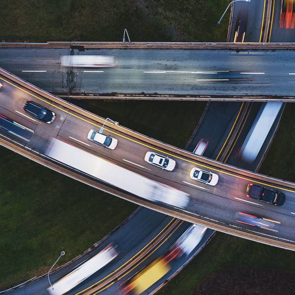 A photo from above of traffic moving quickly on three intersecting highways.