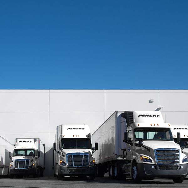 A private fleet of Penske trucks delivering cargo.