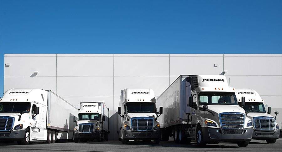A private fleet of Penske trucks delivering cargo.