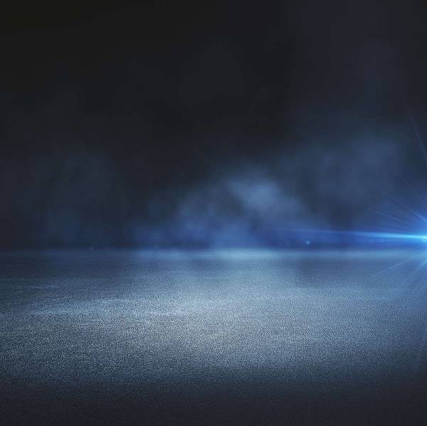 A rainy road with headlights in the distance.