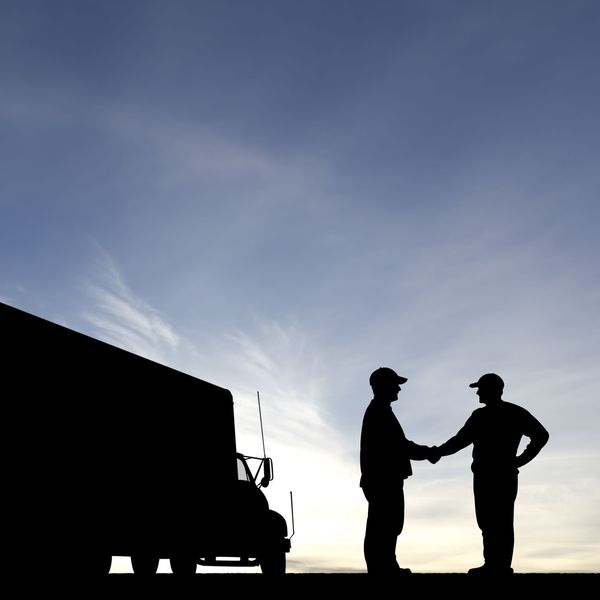 A silhouette of a box truck and two people shaking hands.