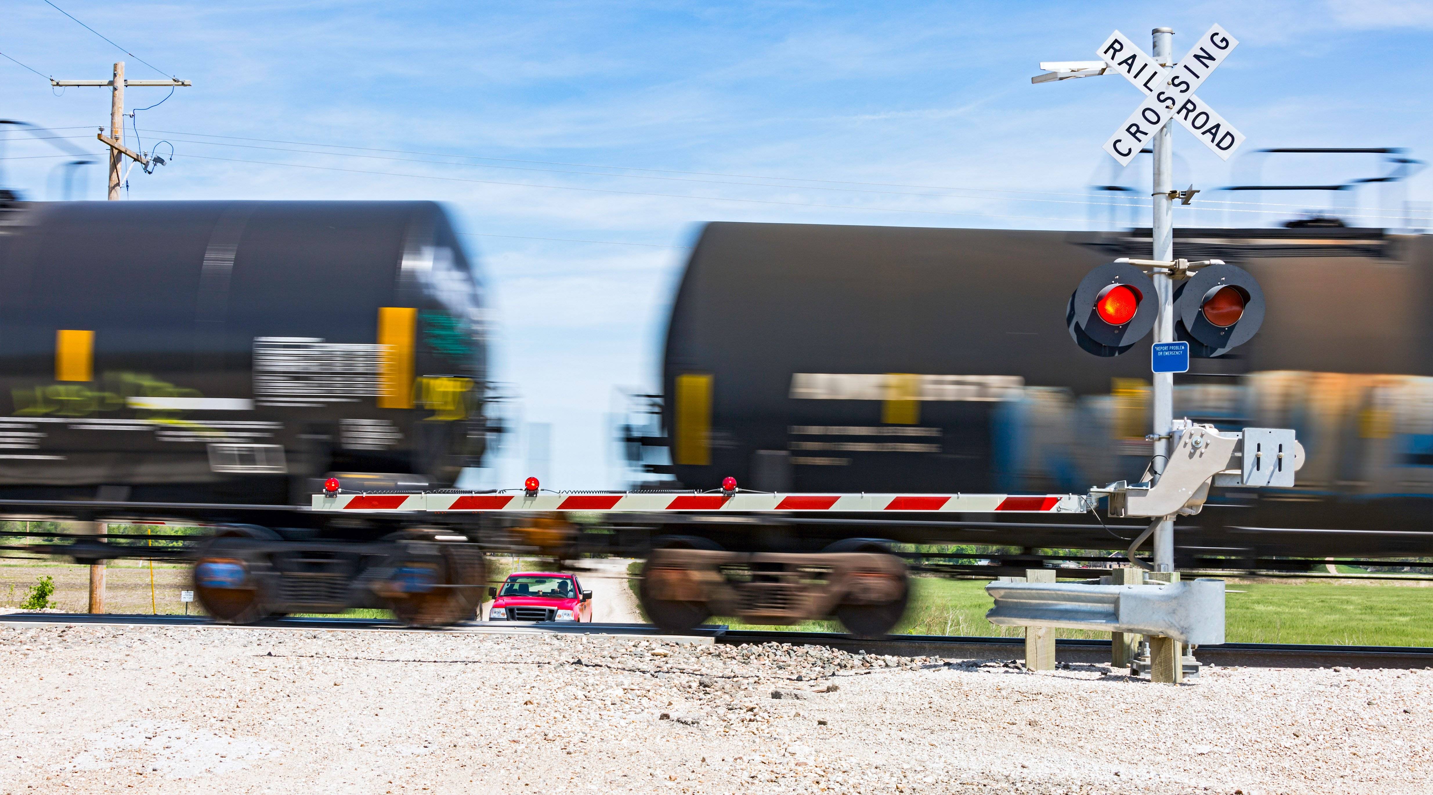A train rushing through a railroad crossing.