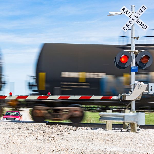 A train rushing through a railroad crossing.
