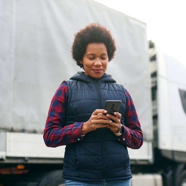 A truck driver looks at her phone