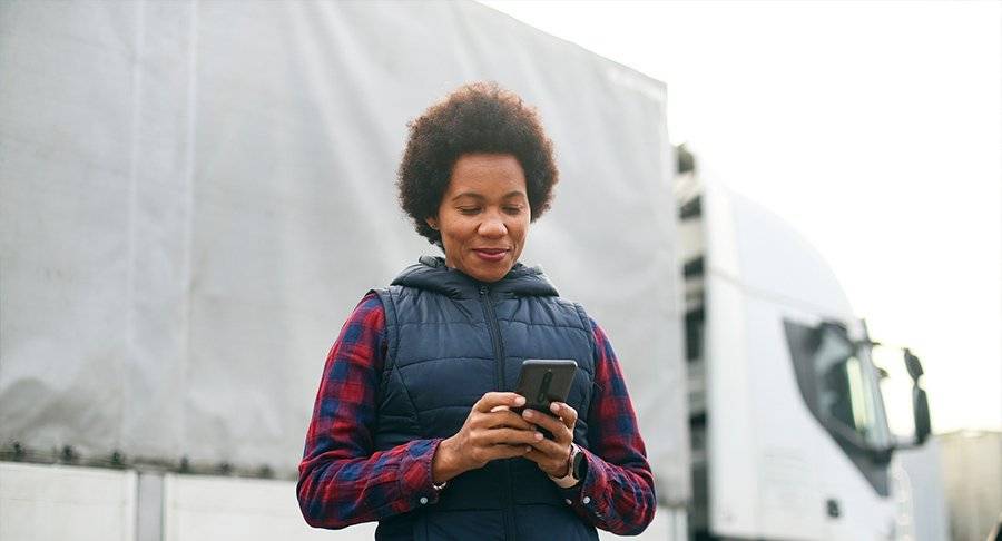 A truck driver looks at her phone