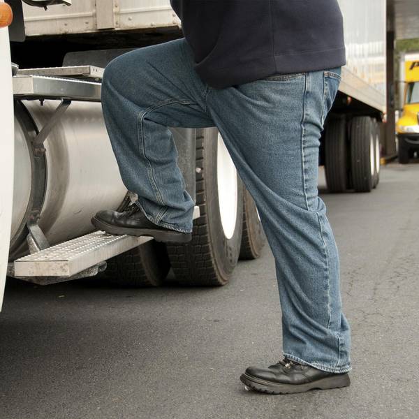 A truck driver steps into a semi truck
