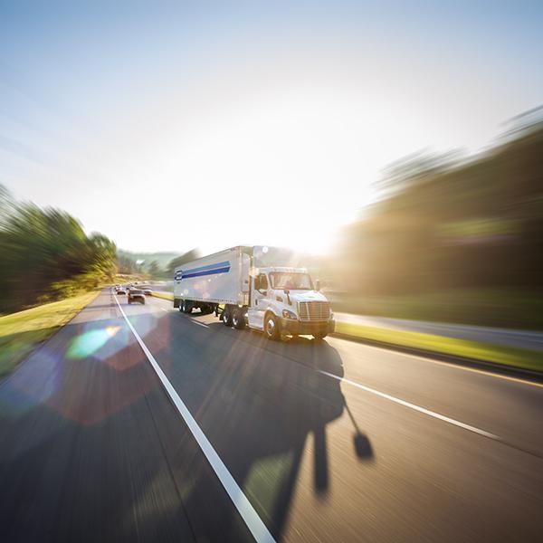 A white Penske Leasing truck is on the road.