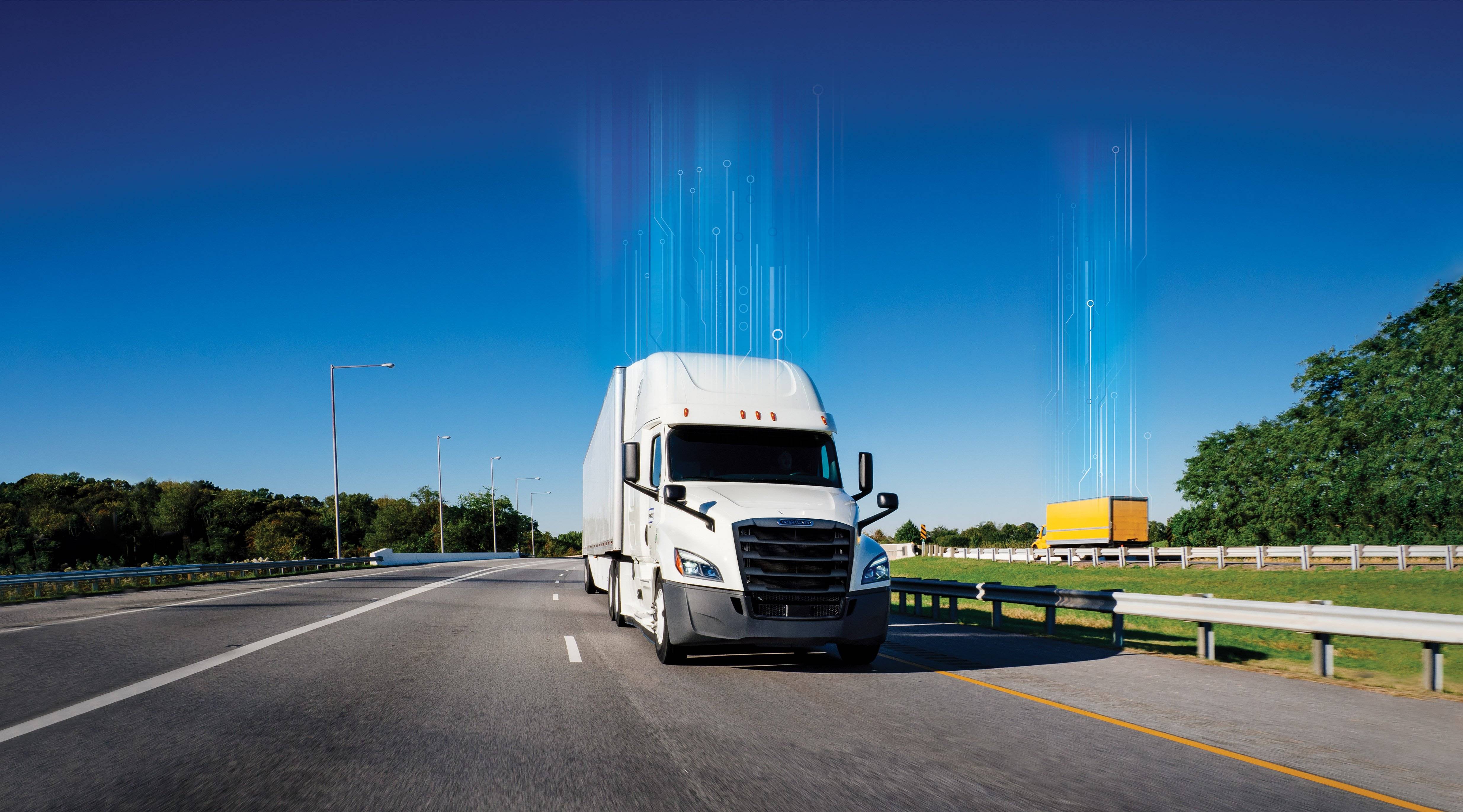 A white tractor truck drives up a freeway.
