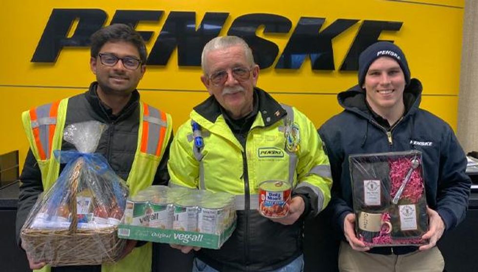 Associates at Penske's Cleveland district pose with their food drive donations and raffle prizes.