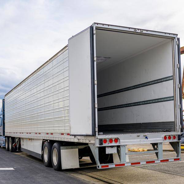 Back of a white semi-truck showing an empty trailer.
