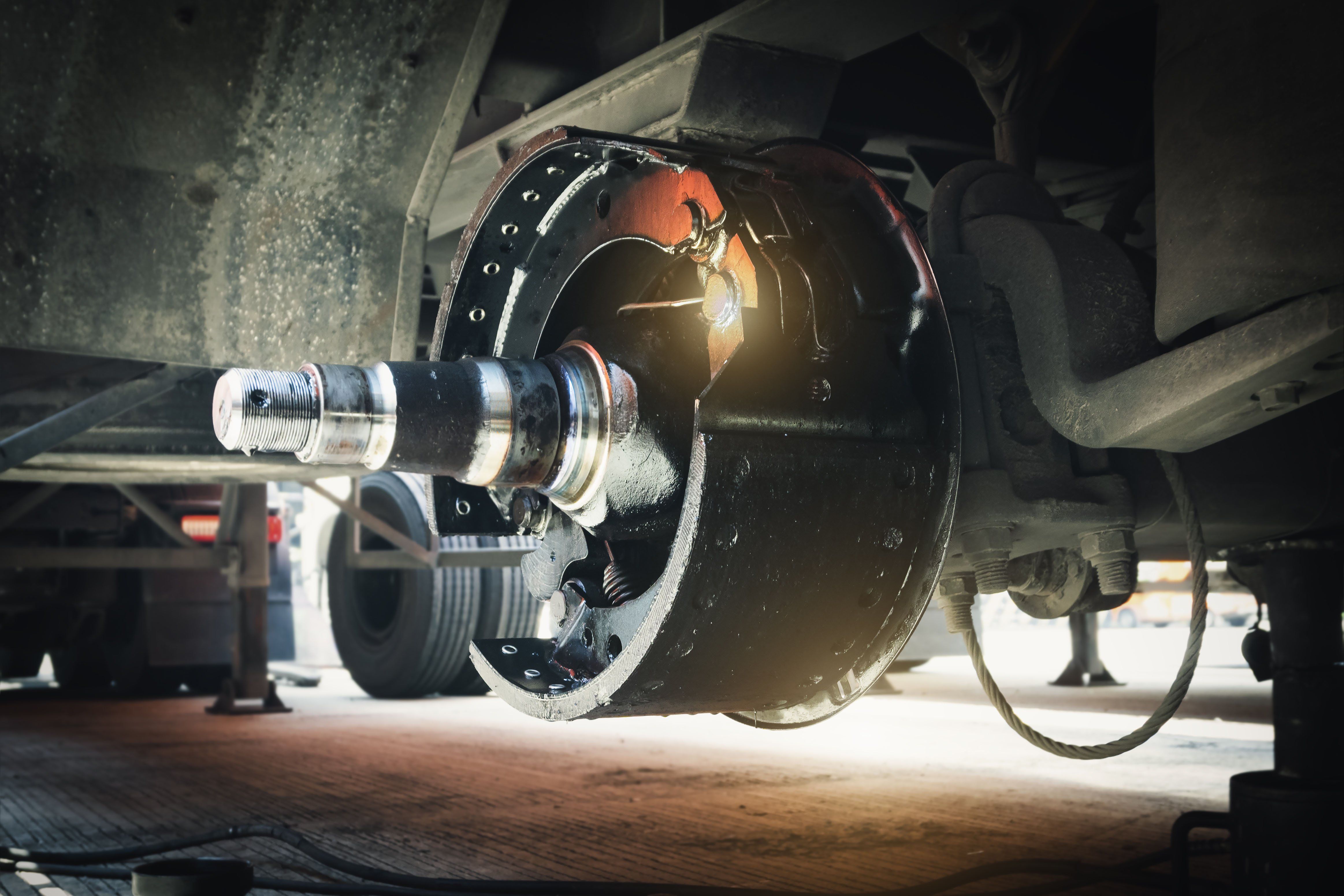 Close-up of break drums and pads on a semi-truck wheel.