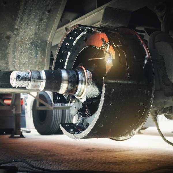 Close-up of break drums and pads on a semi-truck wheel.