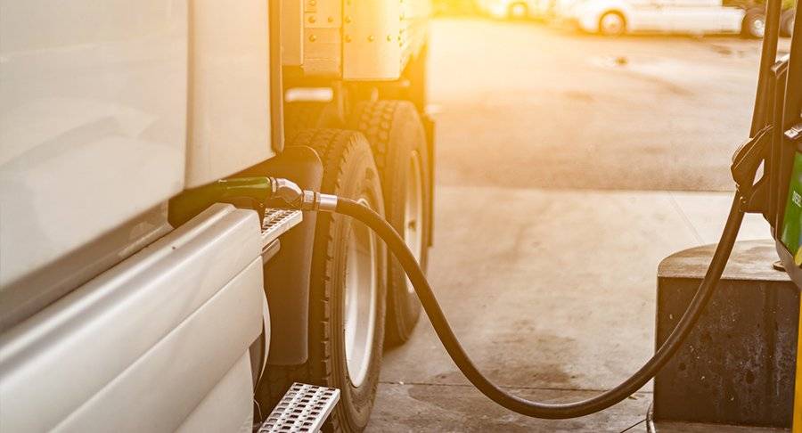 Close up of fuel being pumped into the fuel tank of a truck.