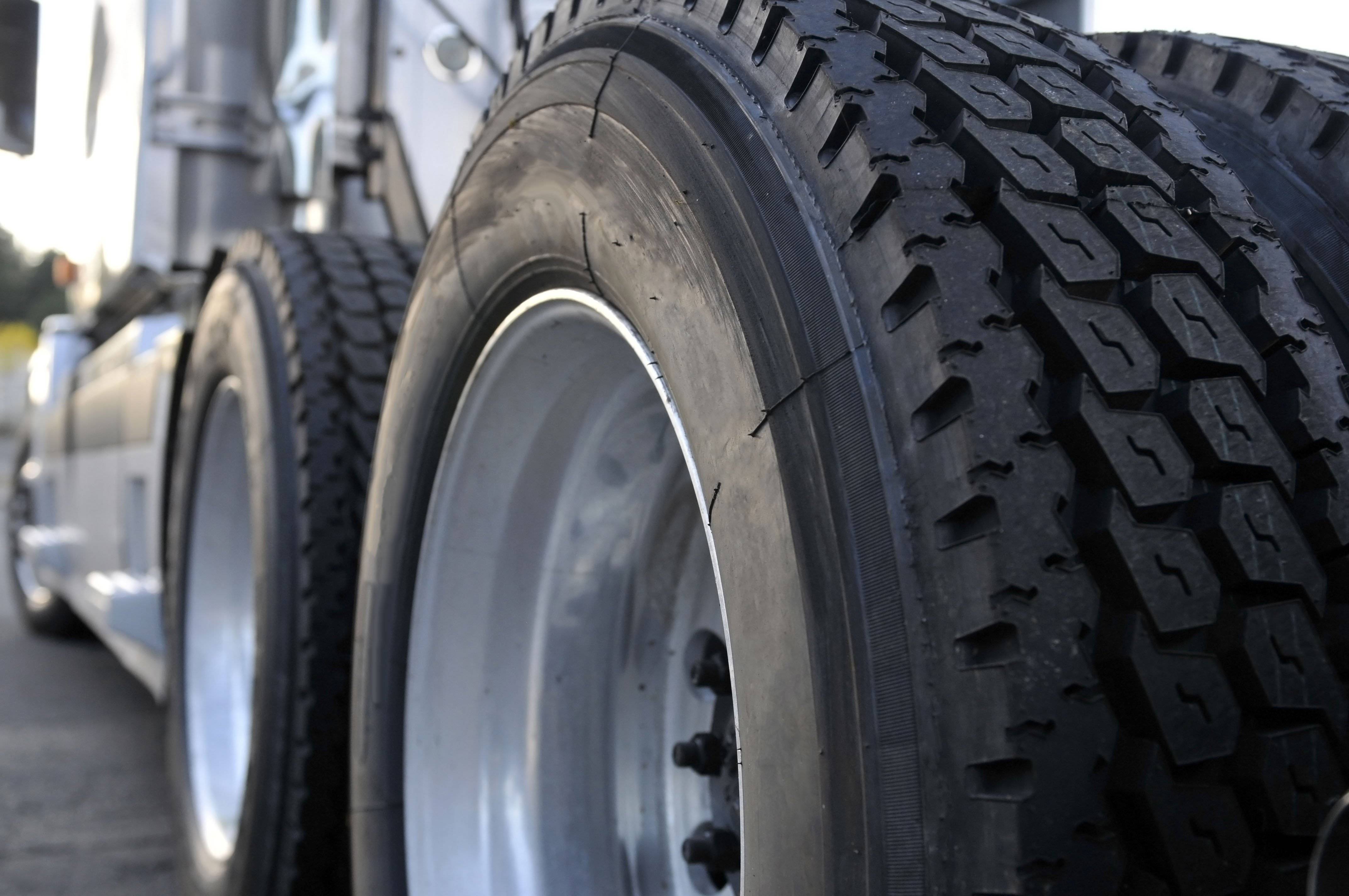 Closeup of two big truck tires on the back of a semi-truck.
