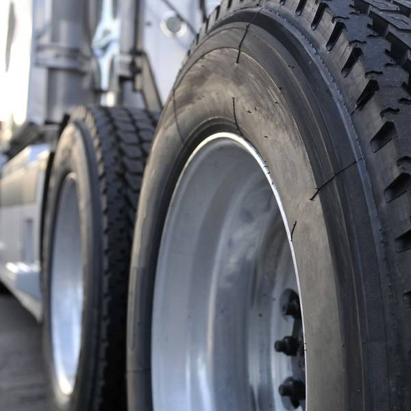 Closeup of two big truck tires on the back of a semi-truck.
