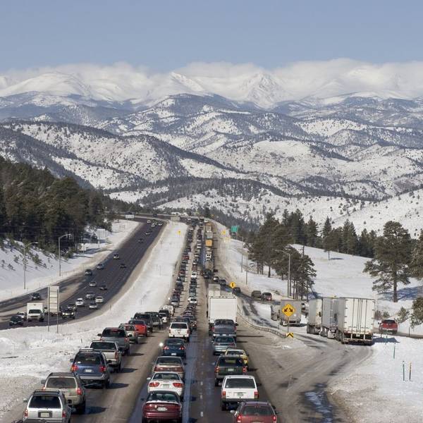 Holiday traffic jam on a snowy highway by the mountains.
