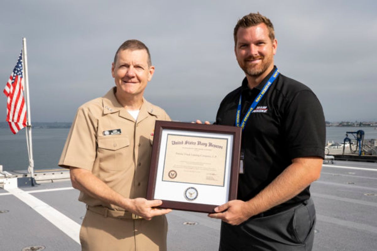 Penske employee receiving certificate of appreciation for Penske's support of Naval employees.