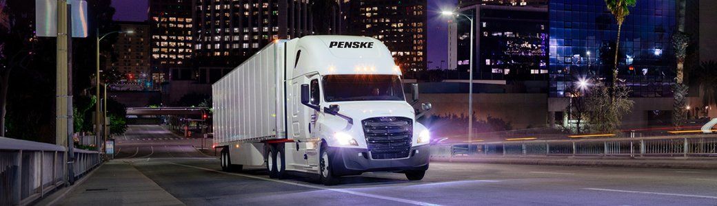 Penske tractor trailer on the highway at nighttime
