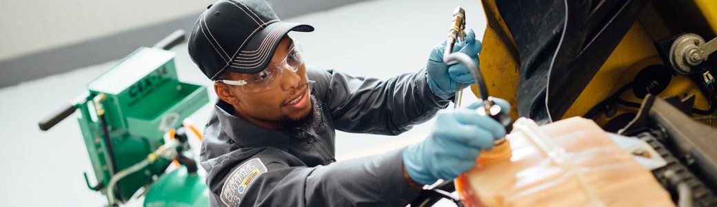 Technician working under the hood of a truck