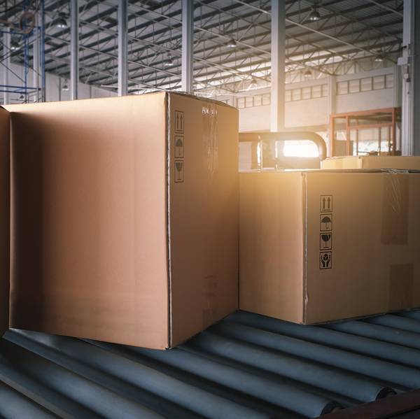 Three boxes on a conveyor in a warehouse.
