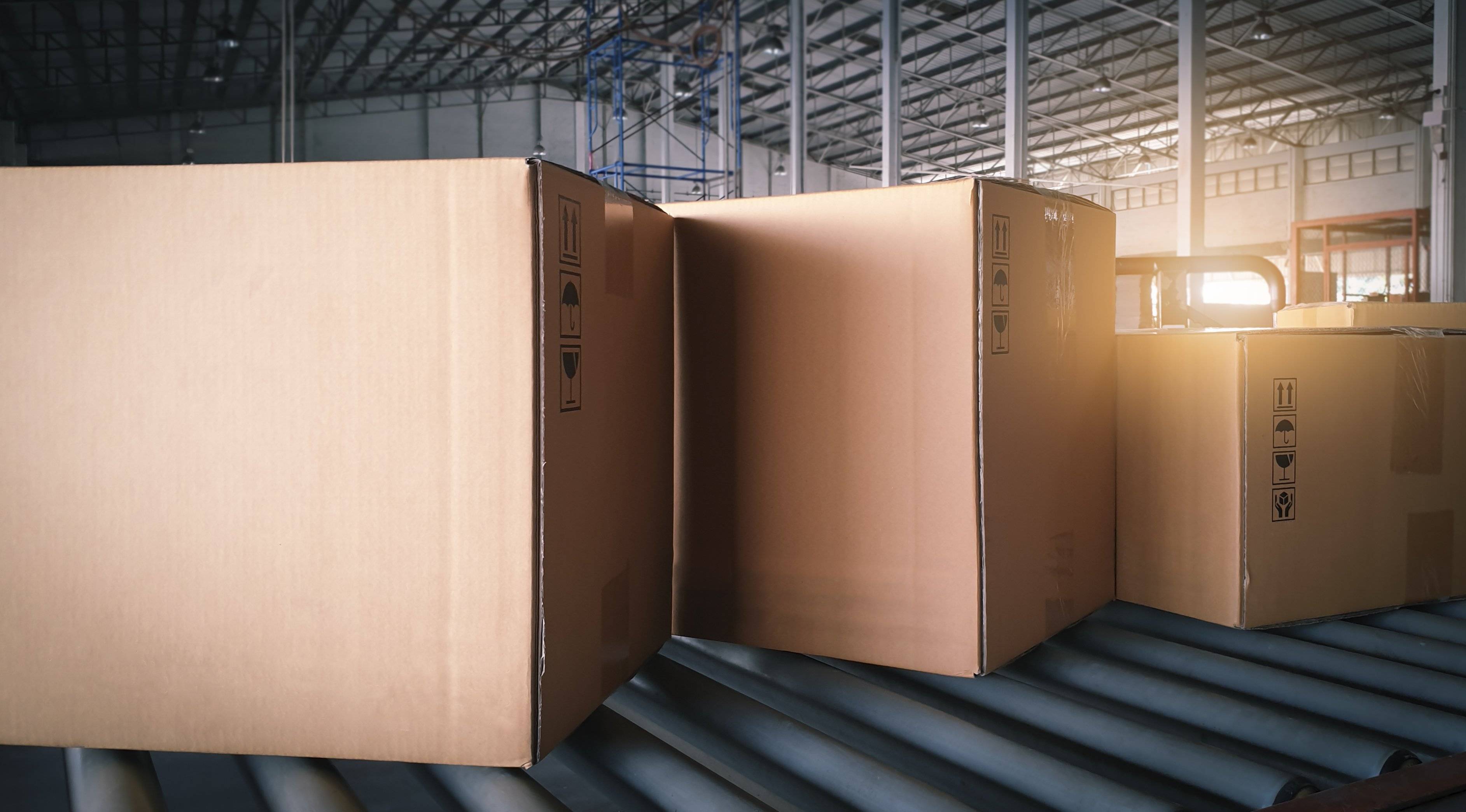 Three boxes on a conveyor in a warehouse.