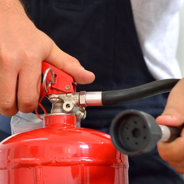 Truck driver holds a fire extinguisher.