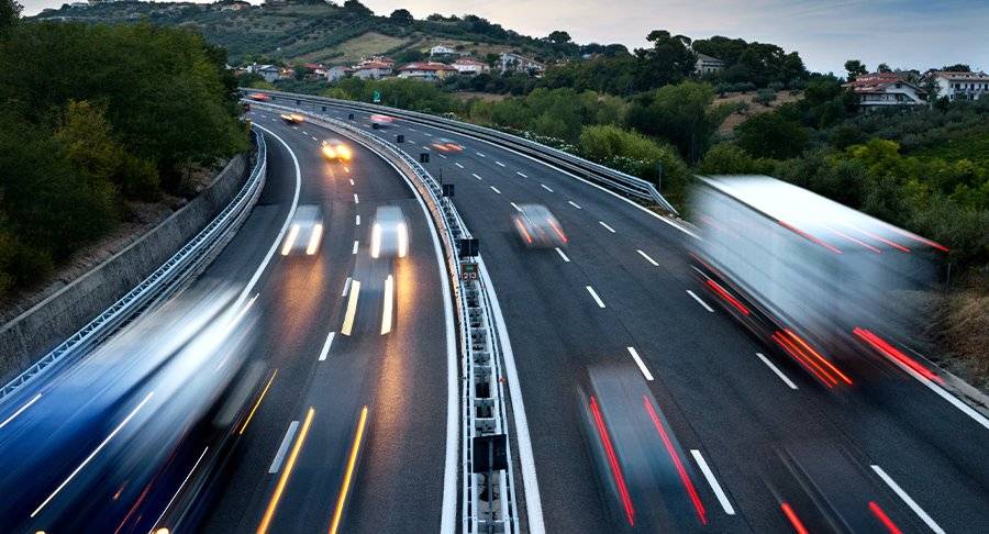 Trucks and cars hit their brakes as they drive up and down a freeway.