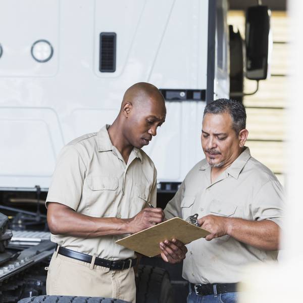 Two men review an inspection list.