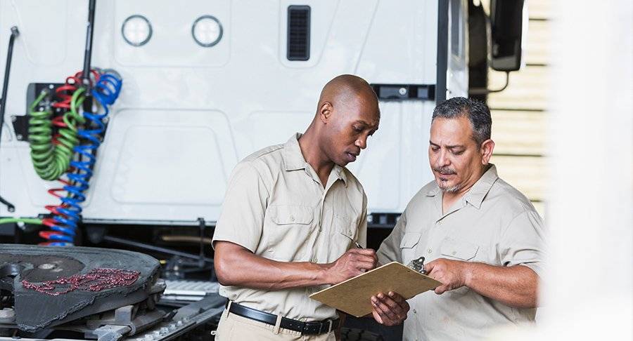 Two men review an inspection list.