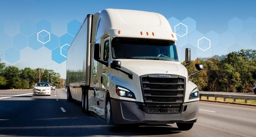 White Penske semi-truck drives over a bridge.